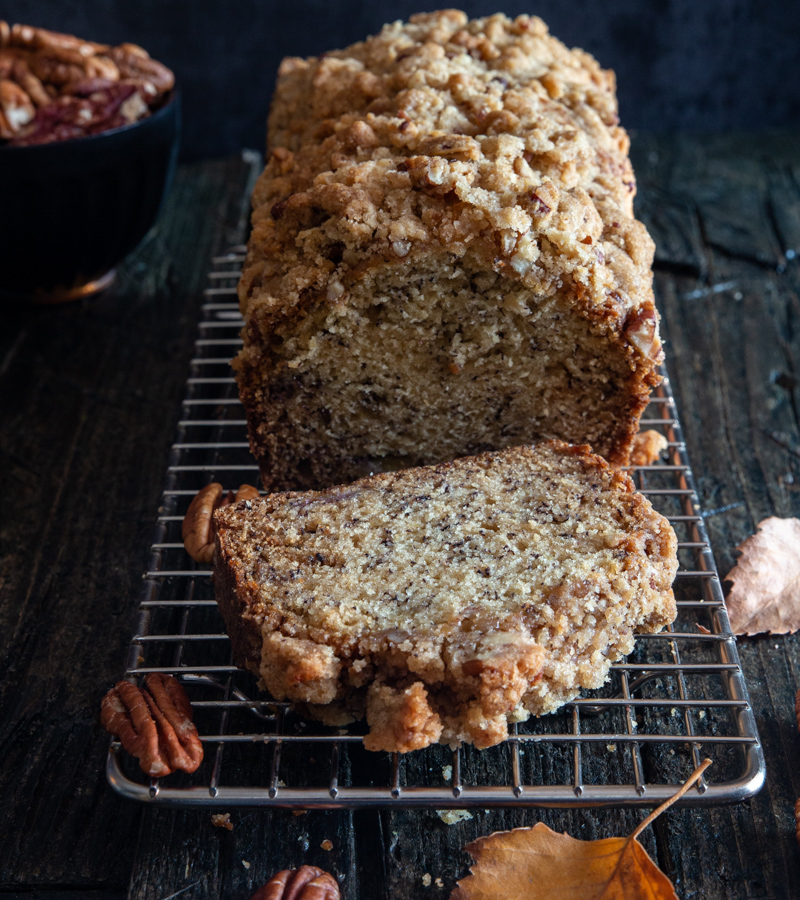 banana bread on a wire rack with a slice cut