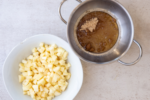 chopped apples and butter melted with brown sugar and water in silver pot