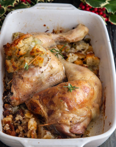 2 whole chicken legs with stuffing in a white pan