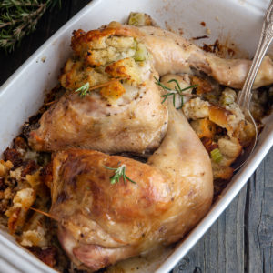 2 whole chicken legs with stuffing in a white pan