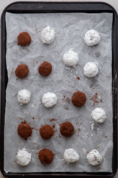rum balls dipped and on a parchment paper cookie sheet