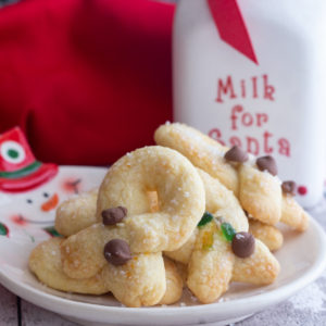 twist cookies on a snowman plate with a milk jug in the back ground