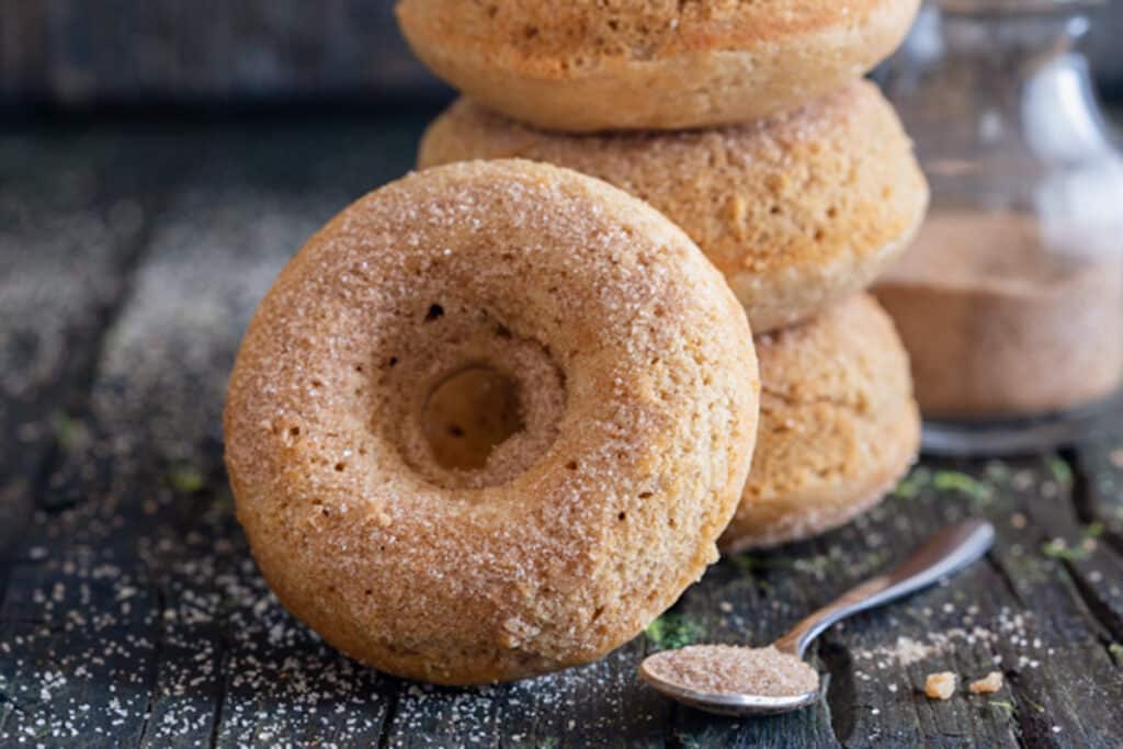 Three donuts stacked with one leaning.