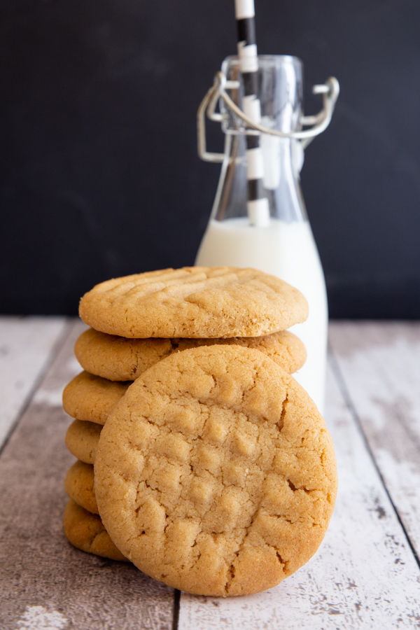 6 stacked cookies with one in front and a small bottle of milk