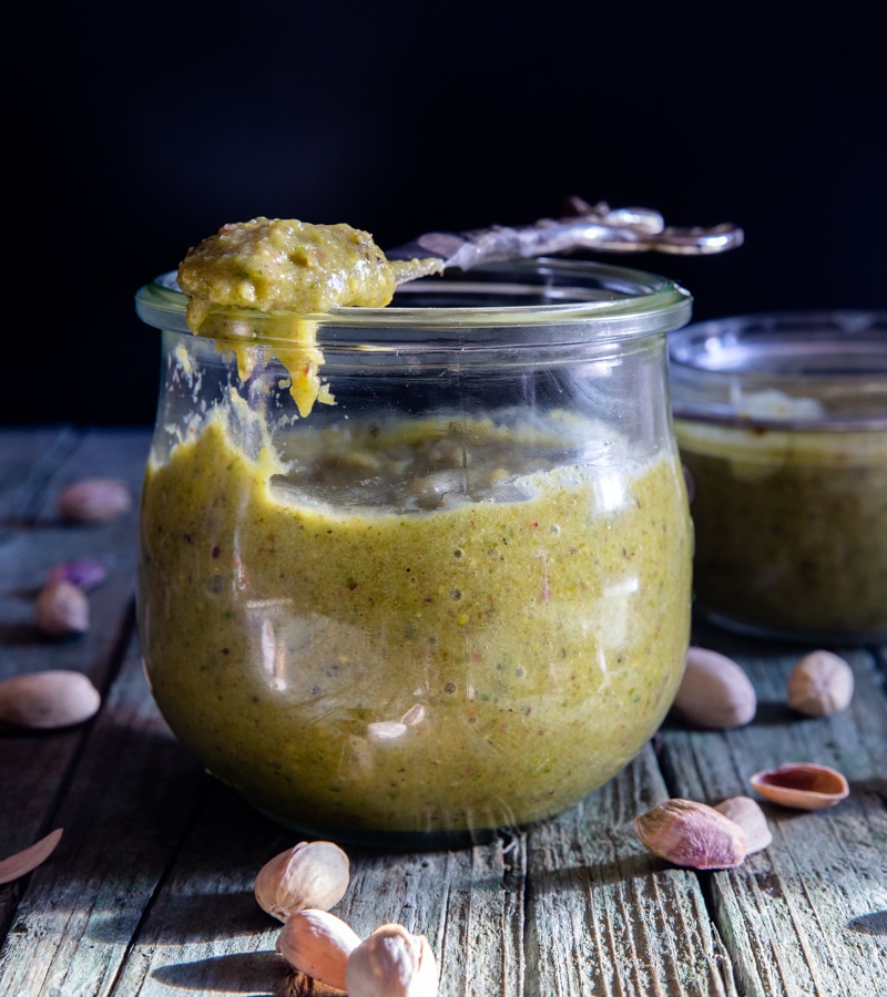 pistachio cream in a jar with some on a spoon