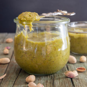 pistachio cream in a jar with some on a spoon
