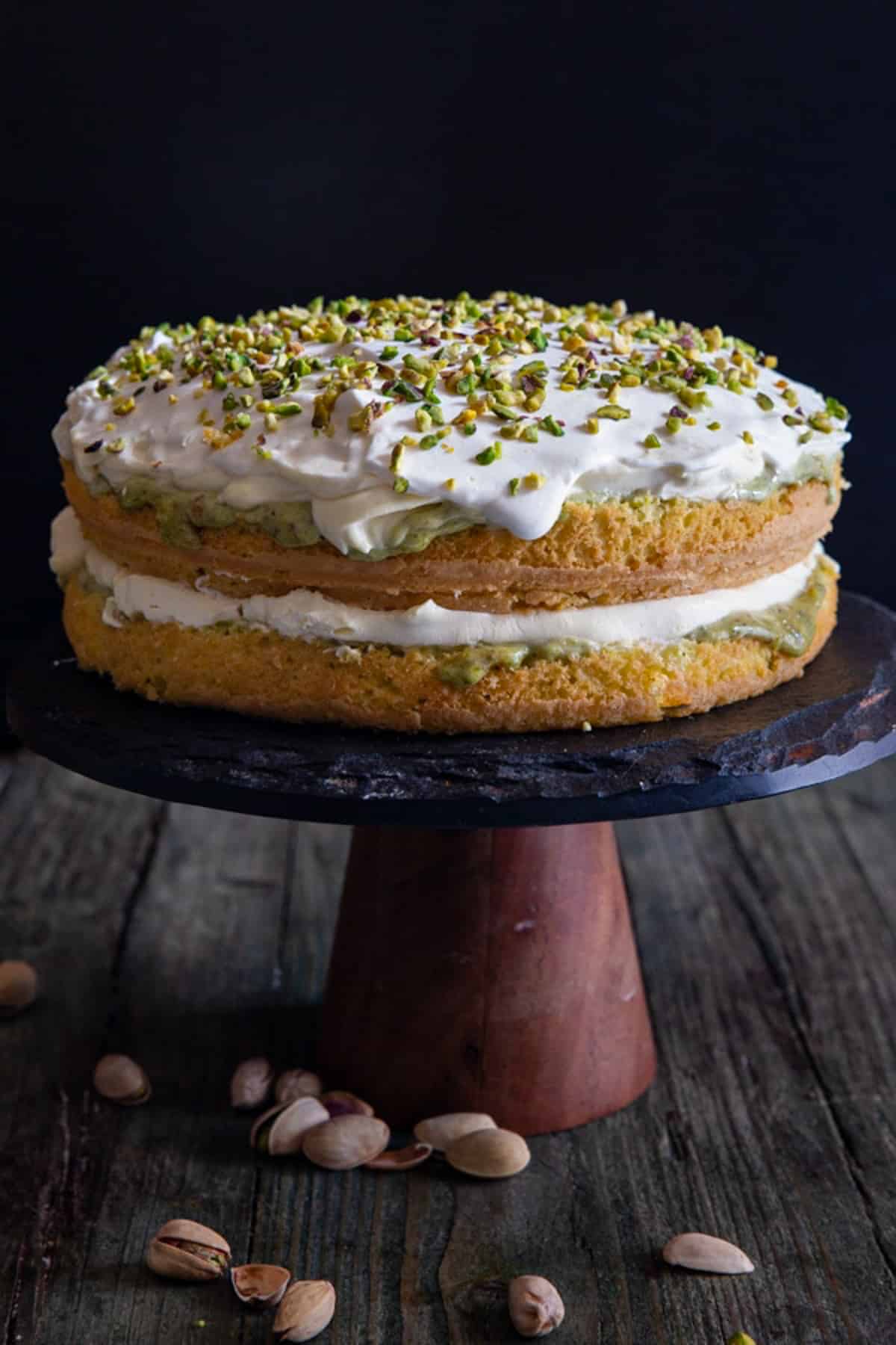 Pistachio Tiramisu on a black cake stand.