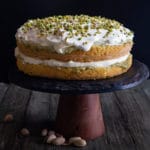 pistachio tiramisu cake on a black cake stand