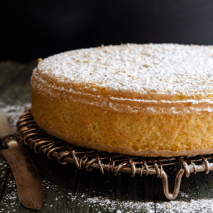sponge cake on a wire rack dusting with powdered sugar