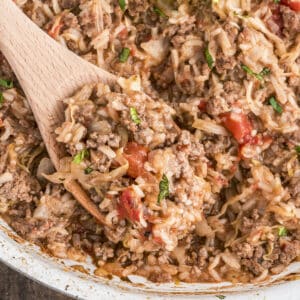 Cabbage roll casserole on a wooden spoon and in the pan.