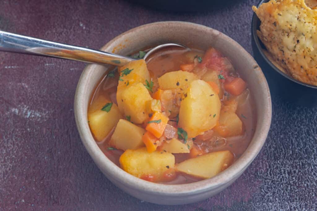 Soup in a white bowl with a silver spoon.