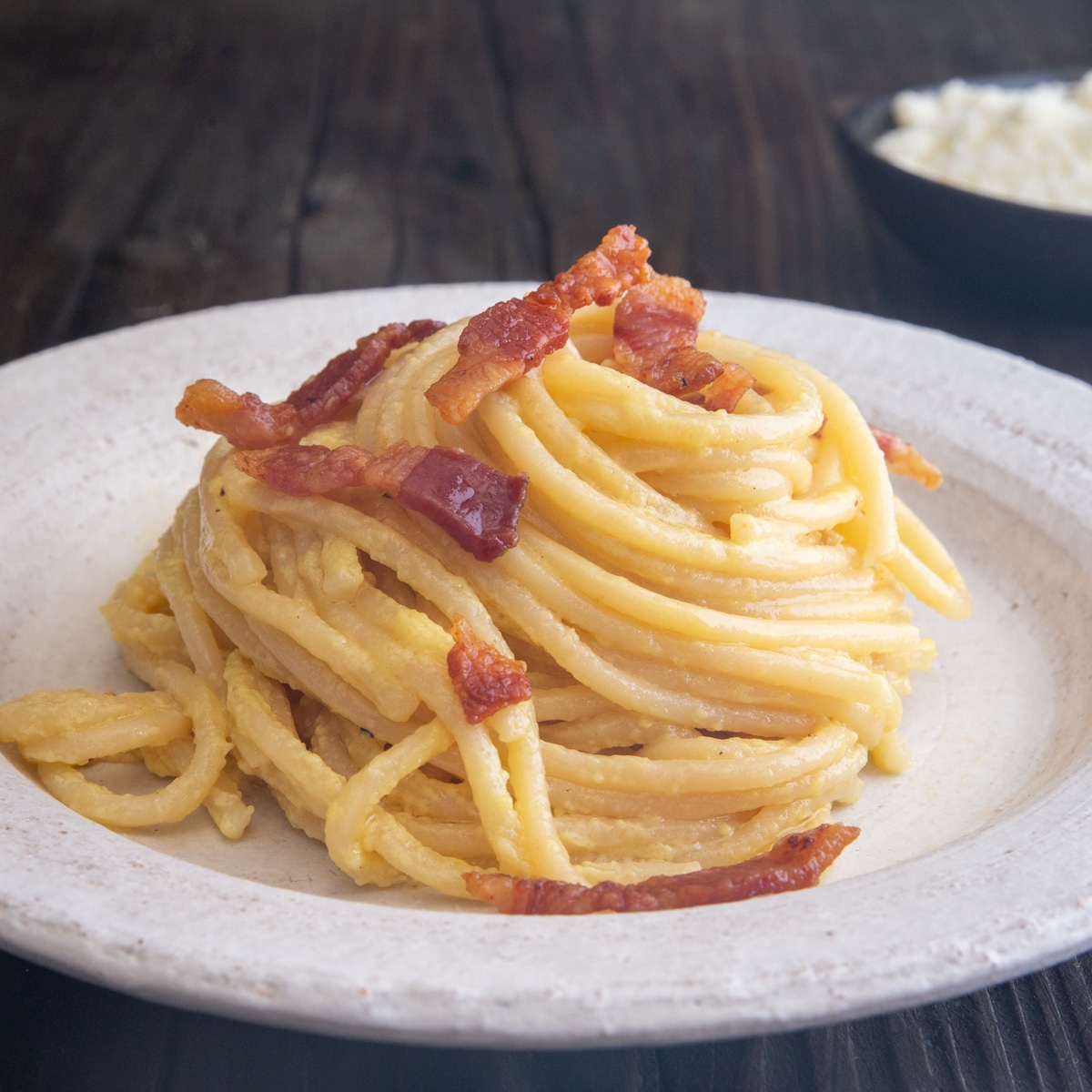 carbonara on a plate with guanciale on top