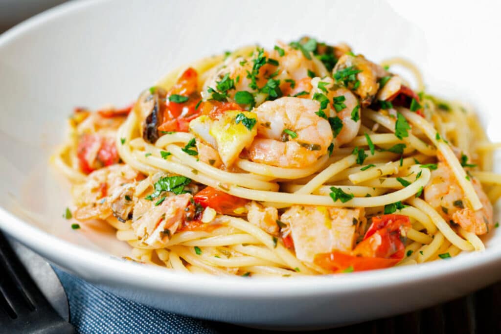 Seafood pasta in a white plate.