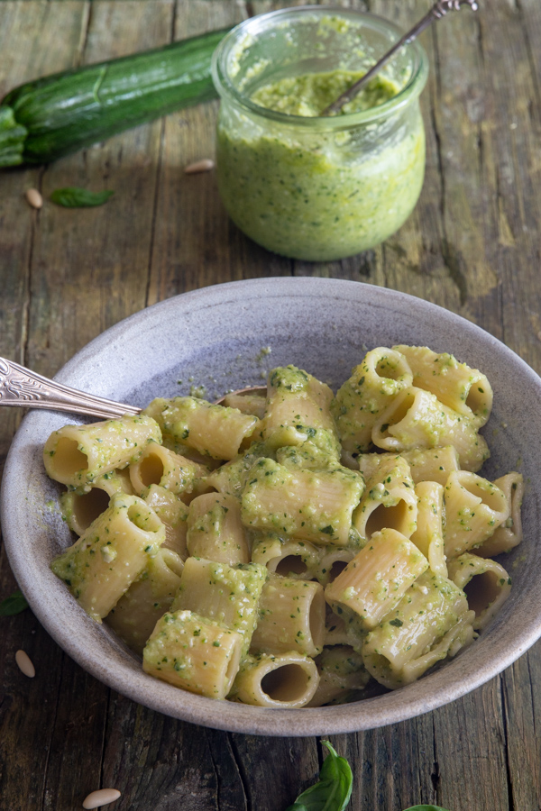 zucchini pesto in a jar & mixed with pasta in a bowl