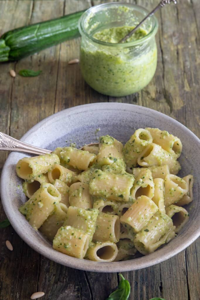 Pasta with pesto in a grey bowl.