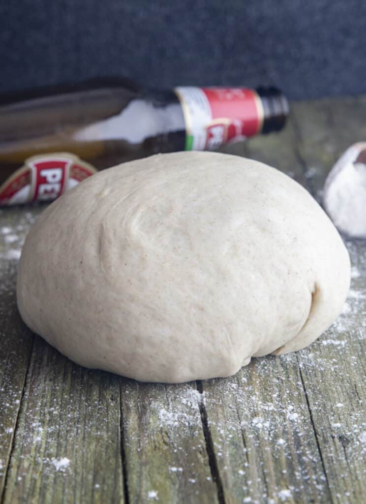 Pizza dough on a wooden board.
