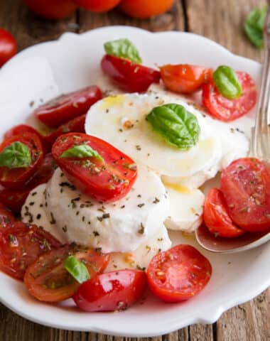 Caprese salad on a white plate.