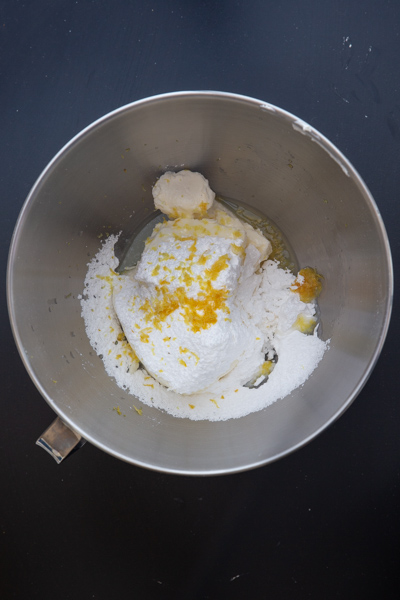cream cheese, sugar, zest and juice in a silver mixing bowl.