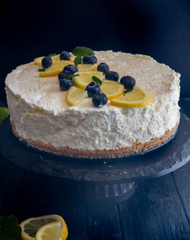 lemon cheesecake on a black stand.