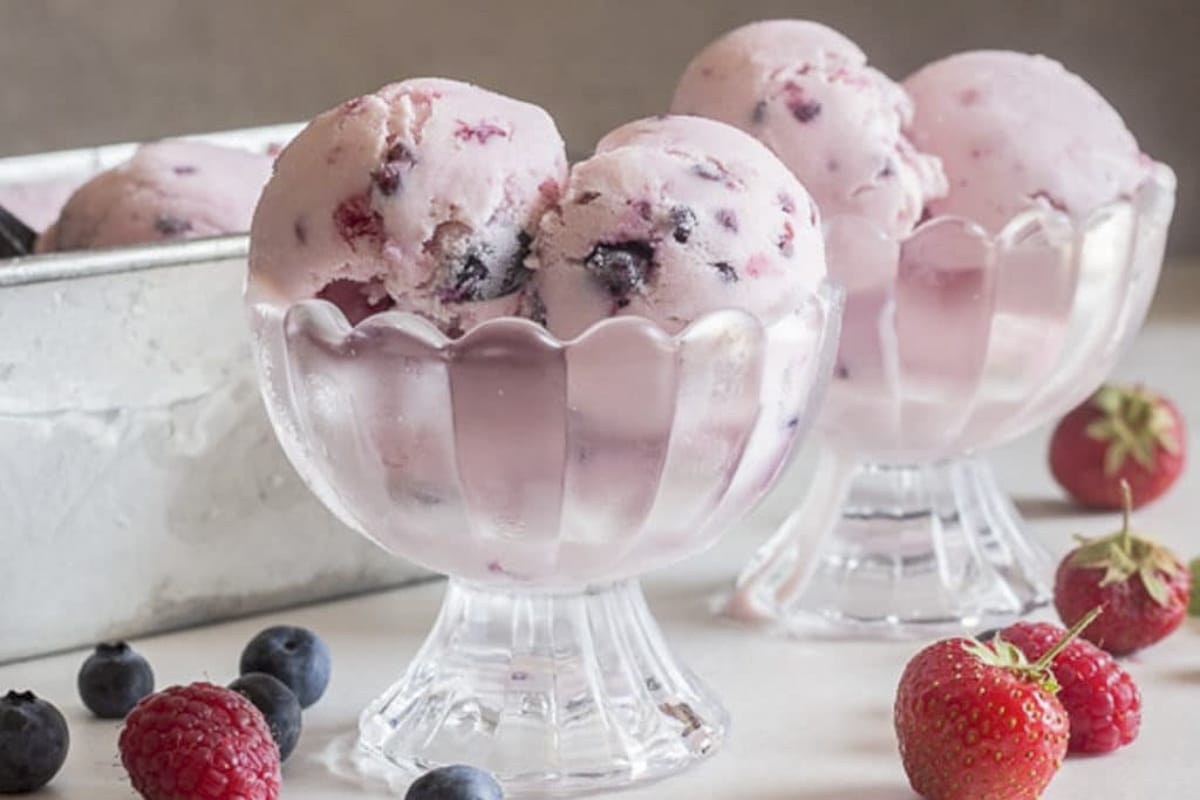 Two scoops of frozen yogurt in two glass dishes.