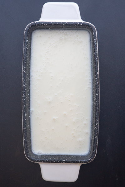 The unfrozen lemon ice cream in a white loaf pan.