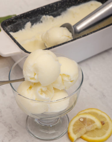 Lemon Ice cream in a glass bowl with remaining in the loaf pan.