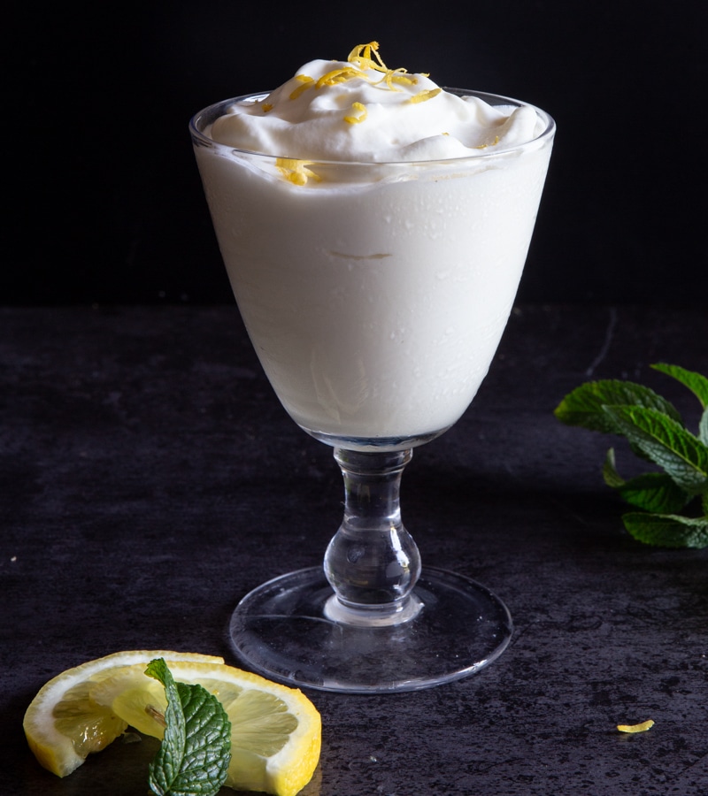 Frozen limoncino in a glass with sliced lemon.