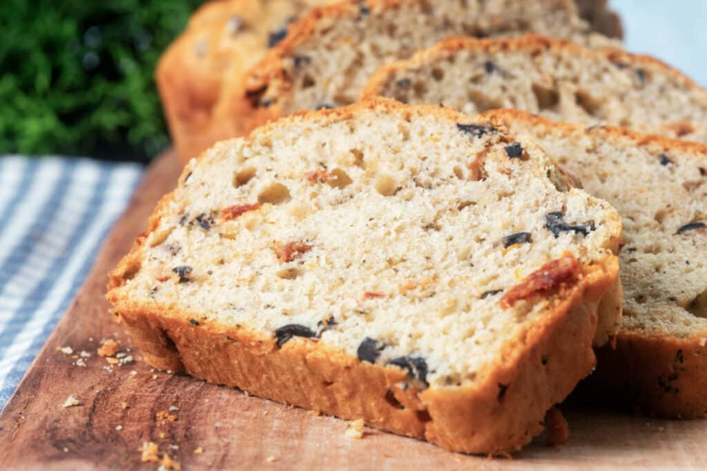 Bread with two slices cut on a wooden board.