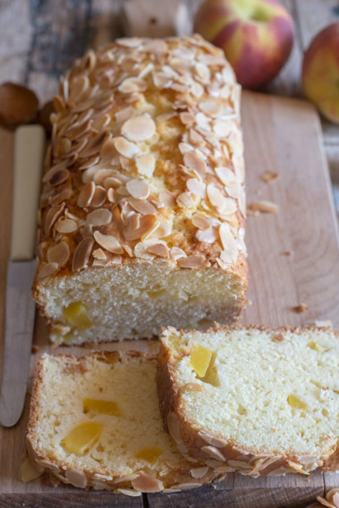 Peach bread with 2 slices on a wooden board.