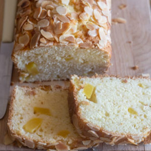 Peach bread with 2 slices on a wooden board.