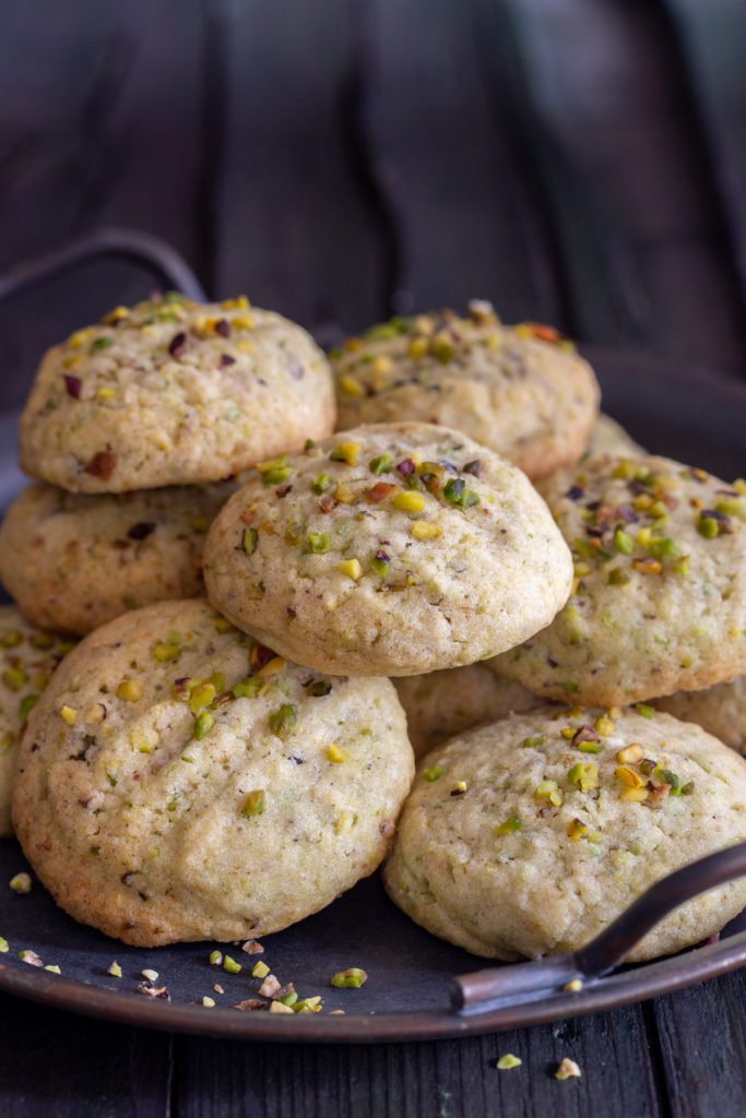 Pistachio cookies on a black tray.