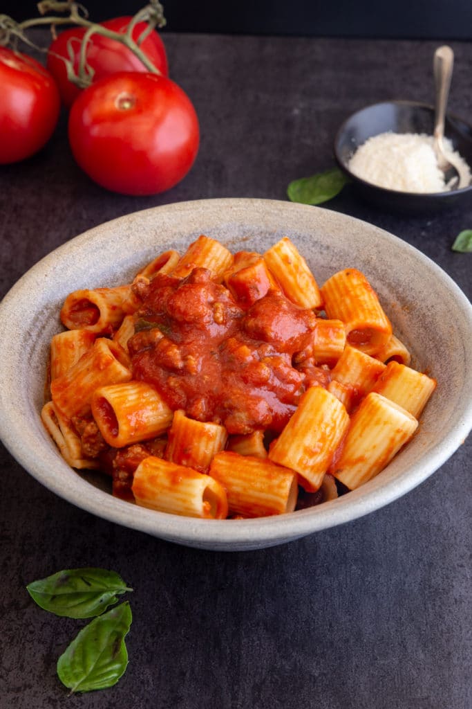 Pasta with sauce in a silver ceramic bowl.