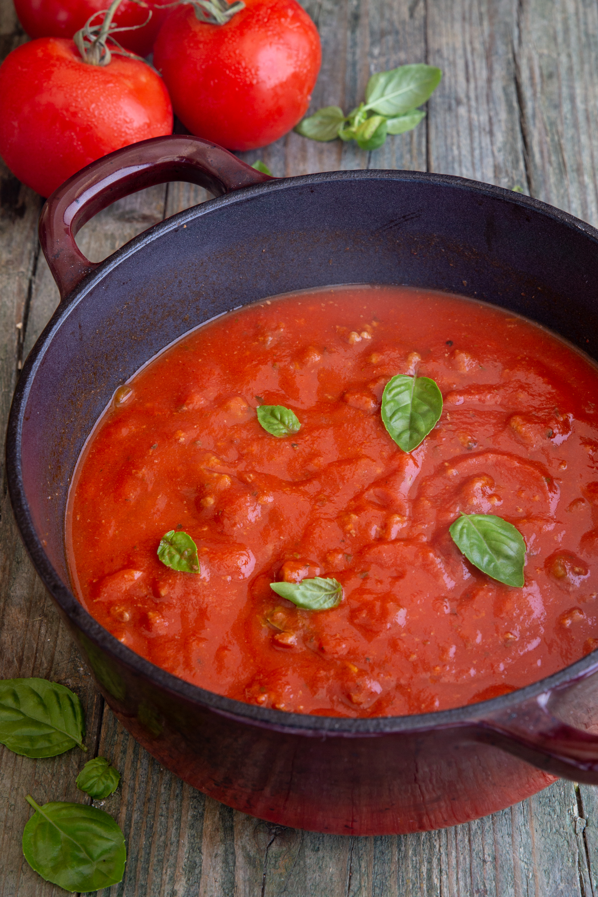 Meat Sauce in a black pot with fresh basil on top.