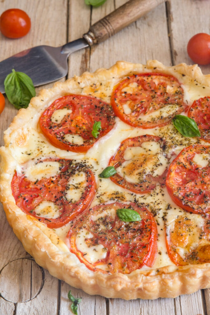 Tomato cheese pie on a white board.