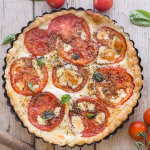 Tomato cheese pie on a white board.