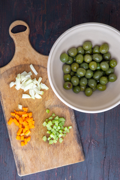 Chopped veggies & plain green olives in a grey bowl.