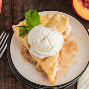 A slice of peach pie on a white plate.