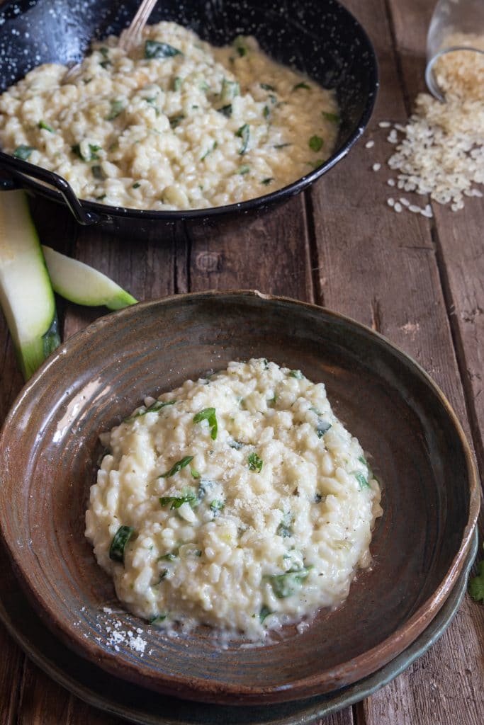 Risotto in a brown plate and in a black pan.