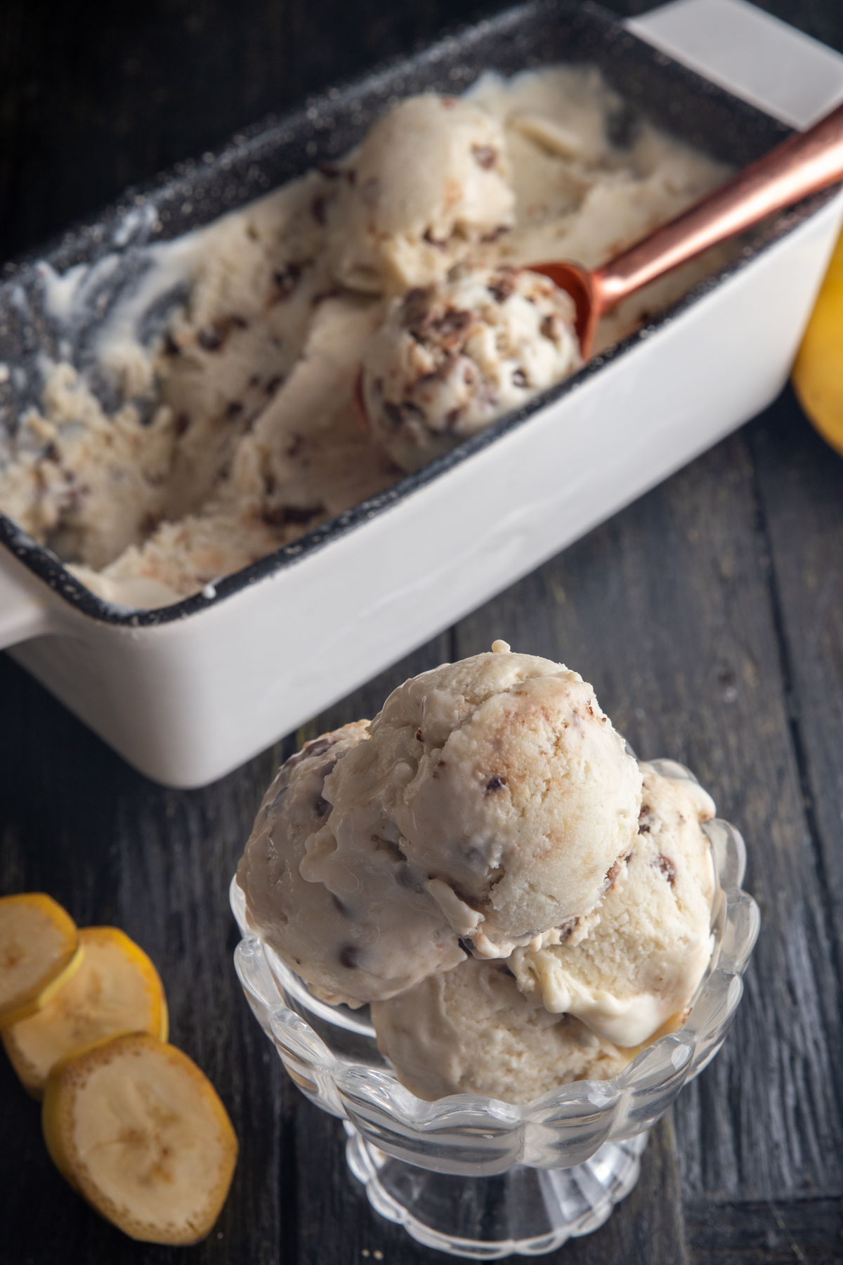 Ice cream in a white loaf pan and 3 scoops in a glass dish.