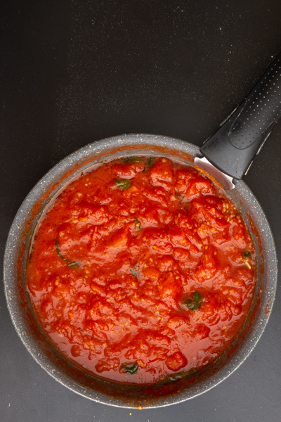 Sauce cooked until thick in a black pan.