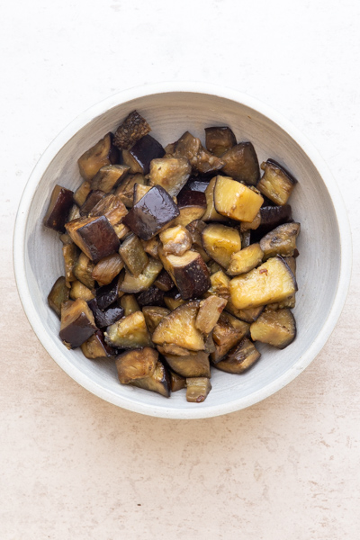 Cooked eggplant in a white bowl.