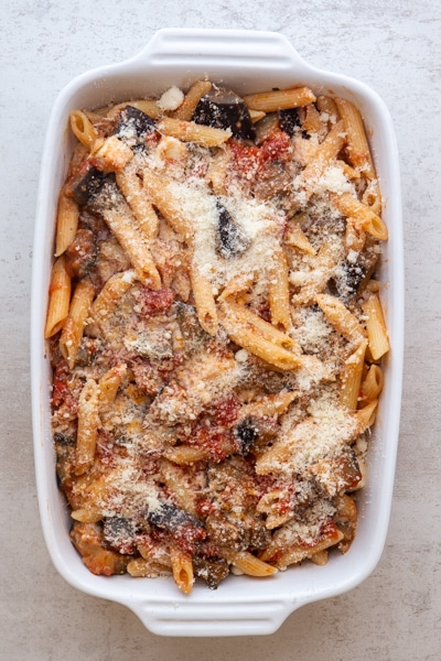 Sicilian pasta ready to be baked in a white baking dish.