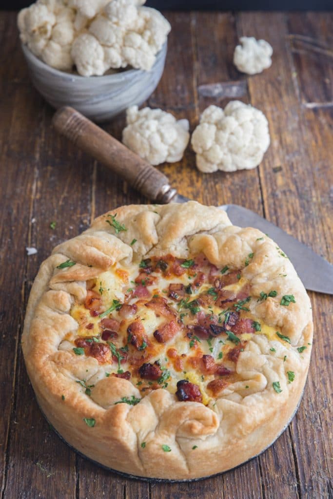 Cauliflower cheese pie baked on a wooden board.