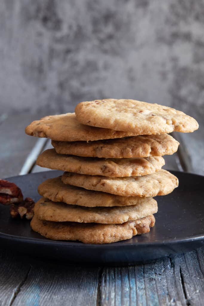 Cookies stacked on a black plate.