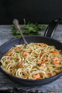 Shrimp pasta in a black pan.