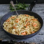 Shrimp pasta in a black pan.