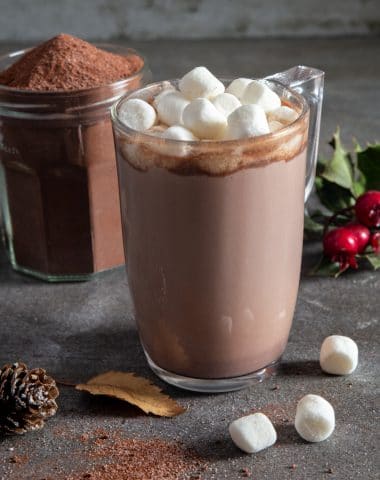 hot chocolate milk in a glass mug and the mix in a glass jar.