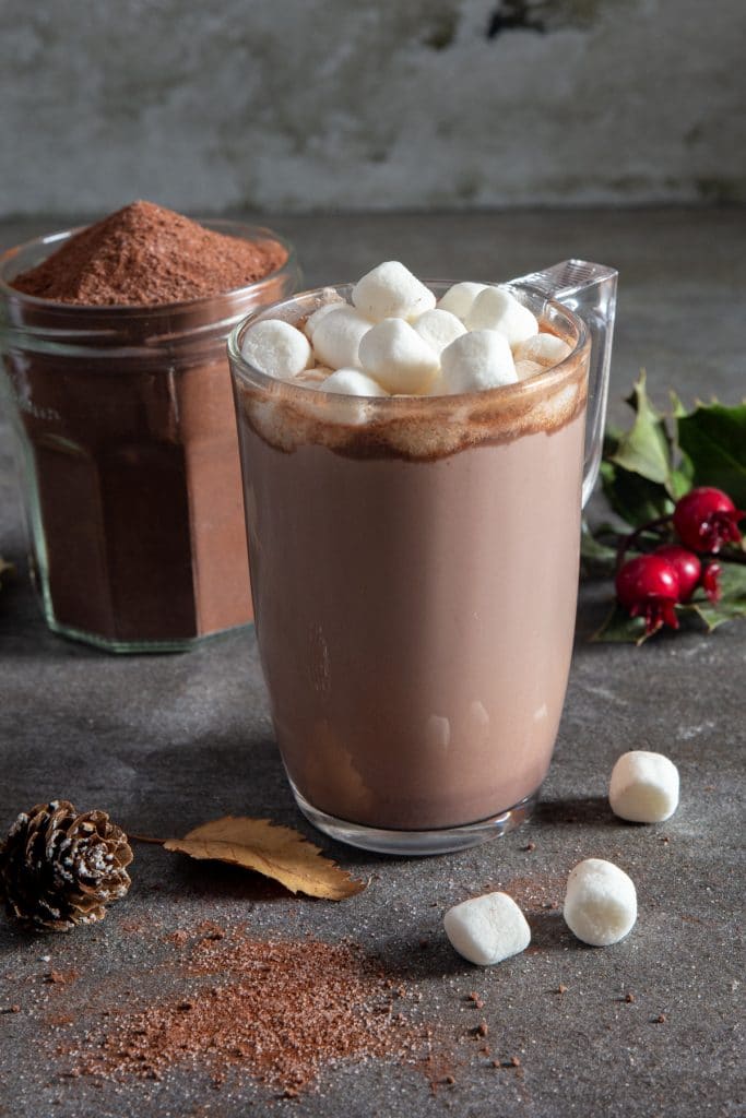 hot chocolate milk in a glass mug and the mix in a glass jar.