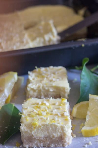 Lemon cheesecake squares cut on a board.