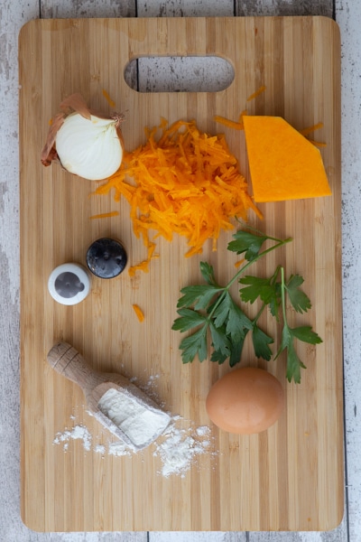 Ingredients for fritters on a wooden board.